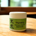 Tenko Premium Organic Matcha container on a wooden surface with a blurred background