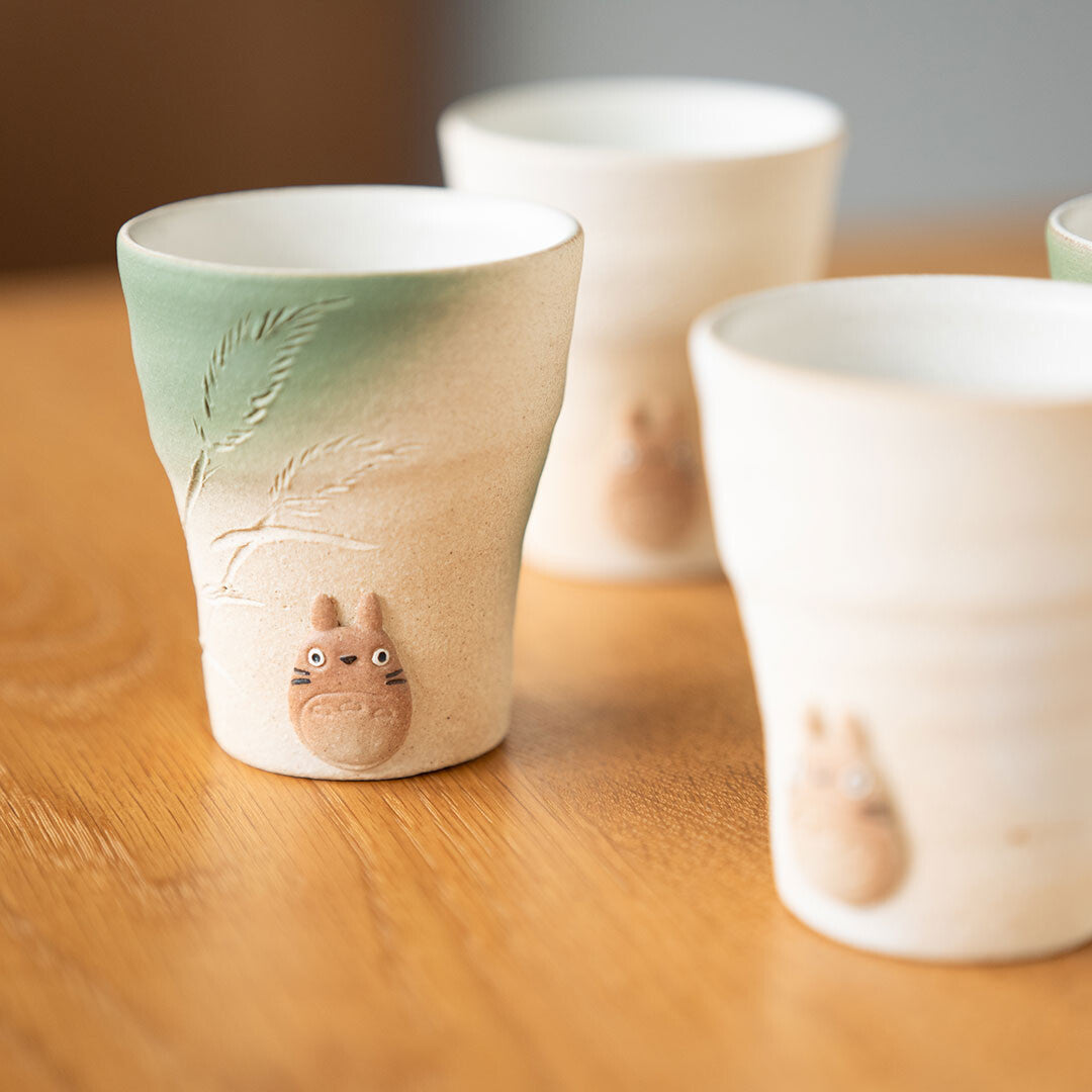 Ceramic cups with animal designs on a wooden surface