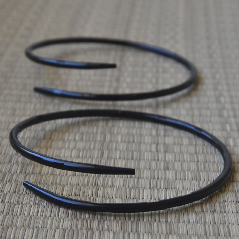 Coiled black metal rod on a textured surface