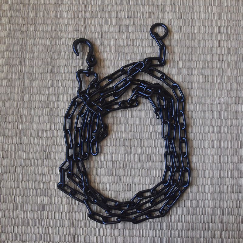 Black chain with hooks on a textured beige background