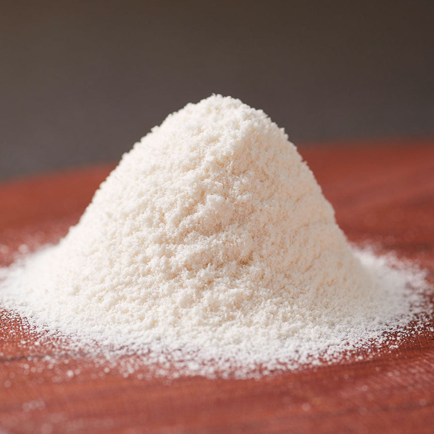 Pile of white wasanbon sugar powder on a wooden surface with a blurred background