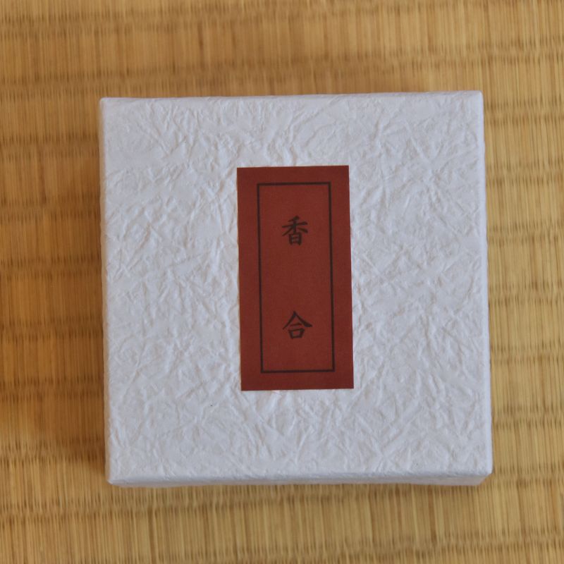 White textured box with a red label featuring East Asian characters on a tatami mat surface