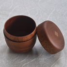 Wooden container with lid on a textured gray background