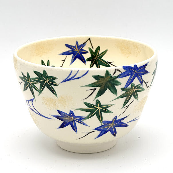 Hand-painted Kyo Ware matcha bowl featuring Aomomiji green maple leaves and flowing blue water on a warm ivory glaze