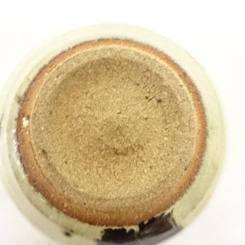 Underside view of the Spotted Karatsu matcha bowl showing the broad unglazed foot, warm clay tones, and dark glaze accent near the edge.