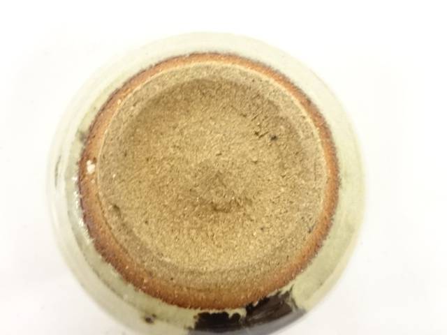 Underside view of the Spotted Karatsu matcha bowl showing the broad unglazed foot, warm clay tones, and dark glaze accent near the edge.