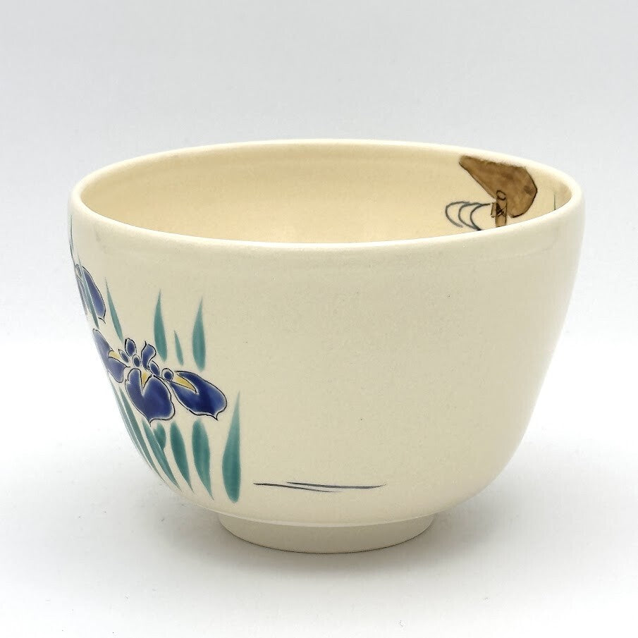 Angled view of the hand-painted Ayame Kyo Ware matcha bowl showing blue iris blossoms and graceful green foliage