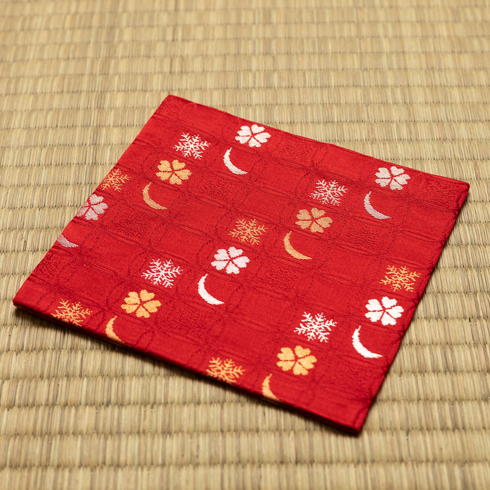 Angled view of the hand-sewn wine red Chitose-bon kobukusa resting on a tatami surface.