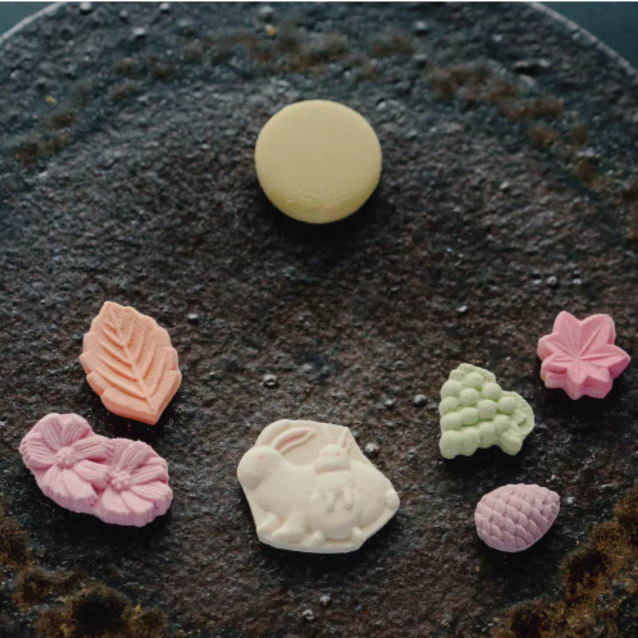 Assorted colorful candy pieces on a textured dark surface