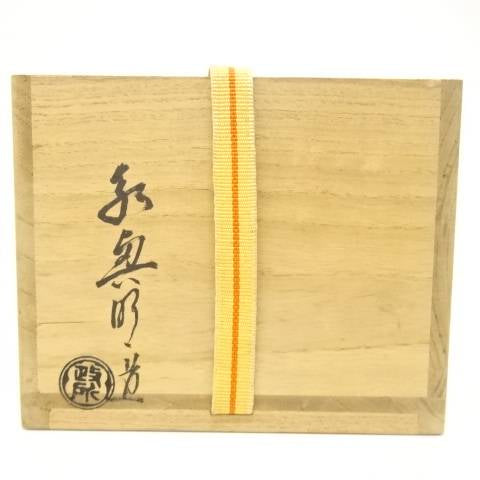 Exterior of the original wooden storage box with Japanese calligraphy, a circular seal, and a yellow securing cord.