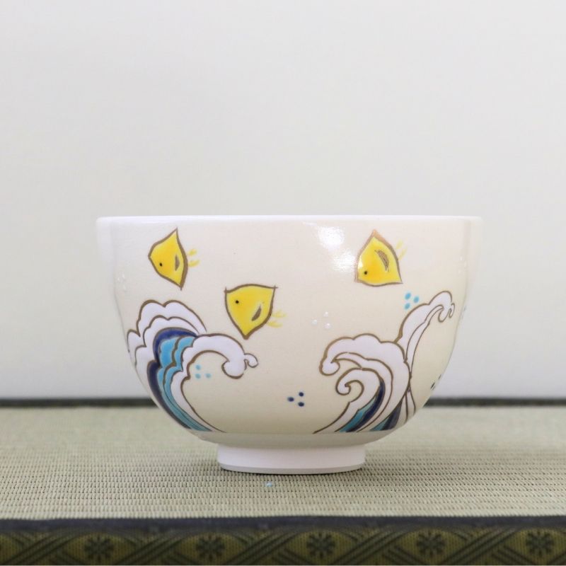 Ninsei-style Kyo-yaki matcha bowl by Eishin Kato featuring yellow Chidori plovers flying above stylized blue ocean waves on a white glaze
