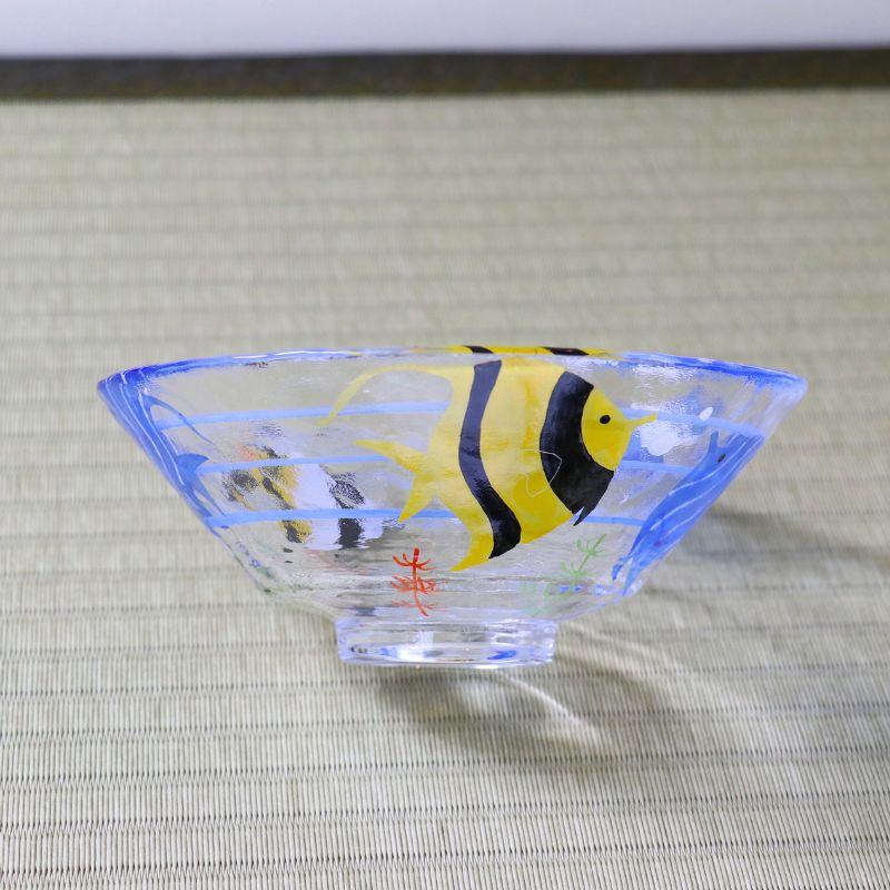Side view of shallow glass matcha bowl with colorful blue and yellow angelfish design