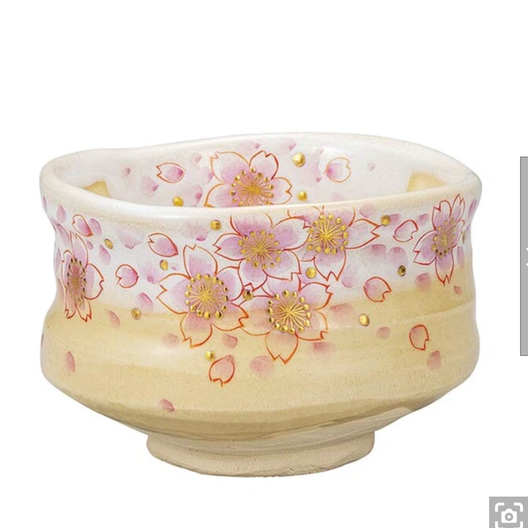 Front view of a hand-painted Kutani Ware matcha bowl covered with pink cherry blossoms, gold leaf accents, and fine gold outlines on a warm ivory glaze.