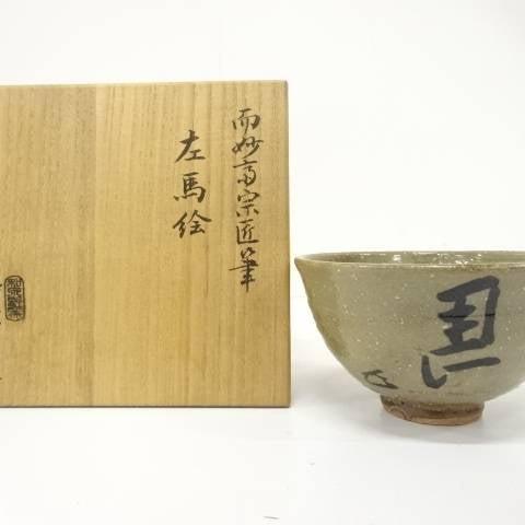 Pre-owned Izumino Ware Hidari-Uma matcha bowl displayed beside its inscribed wooden storage box.
