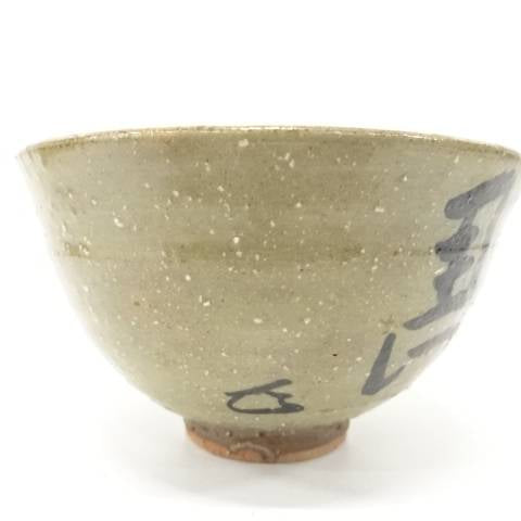 Side view of the pre-owned chawan showing its softly rounded form, olive-gray glaze variation, and painted details near the foot.