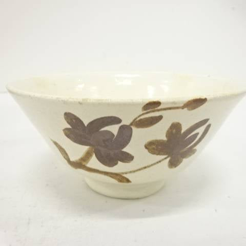 Front view of the Yukiwasou Buncheong chawan showing dark brown iron-painted flowers and leafy stems across a pale ivory surface.