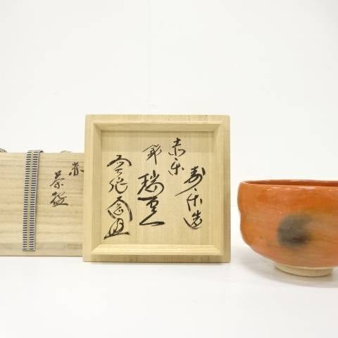 Pre-owned Juraku Aka Raku matcha bowl named Zuiun displayed beside its original Zen-inscribed wooden storage box.