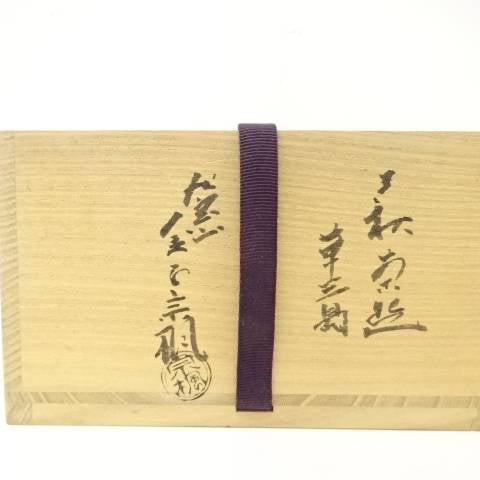 Exterior of the original wooden storage box with Japanese calligraphy, seals, and a dark purple securing band.