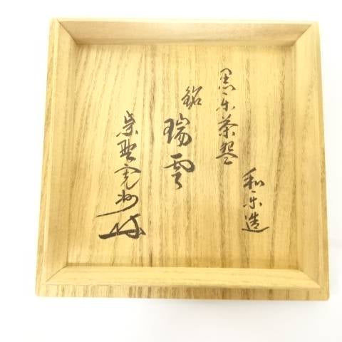 Open wooden storage box with interior inscription accompanying the Kawasaki Waraku Black Raku matcha bowl.