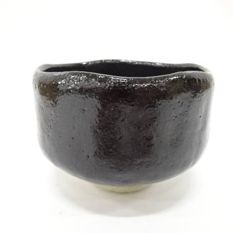 Front view of the pre-owned Kawasaki Waraku Black Raku matcha bowl with a rounded form and glossy black glaze.