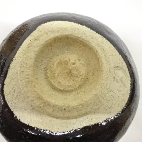 Underside view of the pre-owned Black Raku matcha bowl showing the unglazed foot and base.