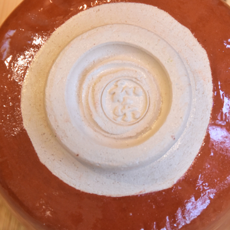 Close-up of the exposed foot and impressed potter mark on the underside of the Kawasaki Waraku matcha bowl.