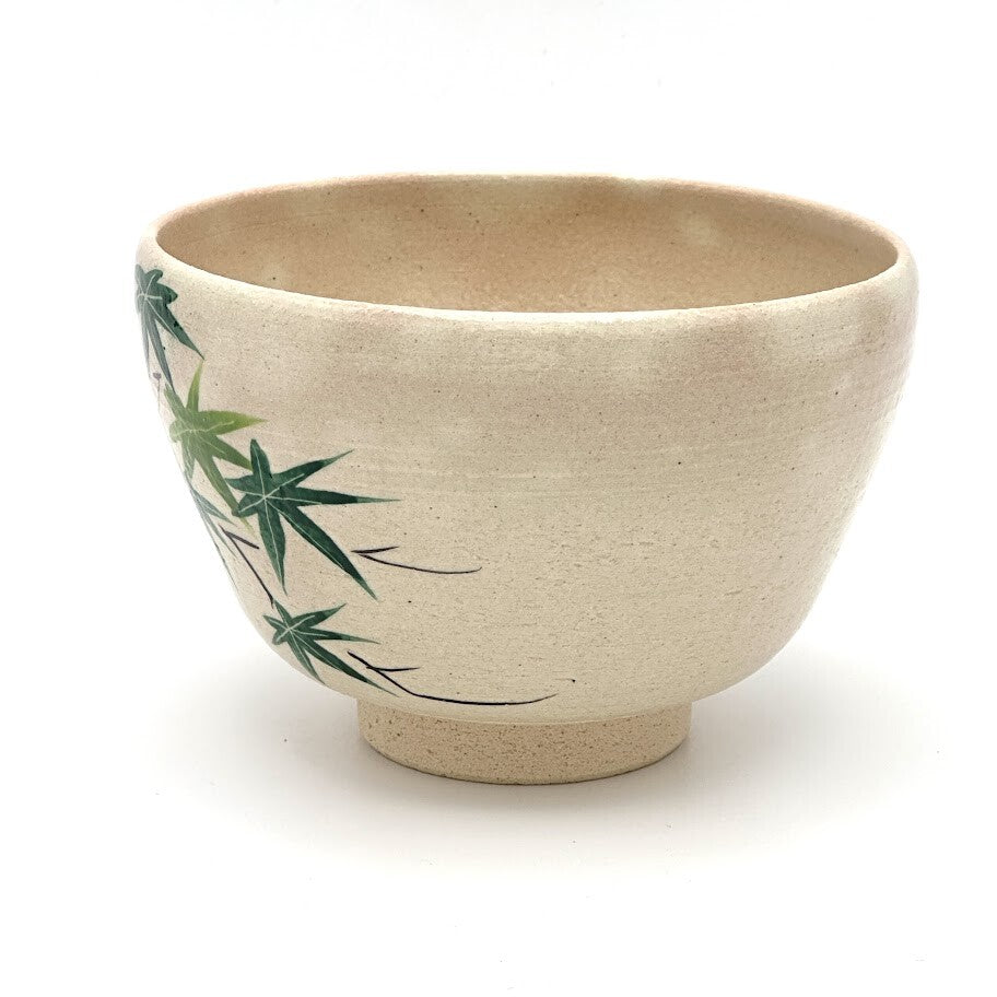 Left-side view of the hand-painted matcha bowl with sweeping green maple branches extending around the curved exterior.
