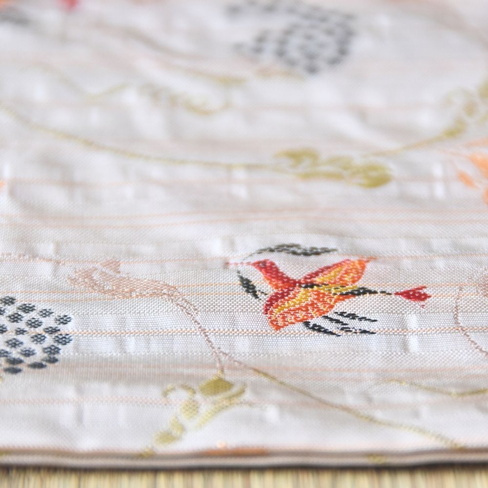 Close-up of a quilt with floral patterns and embroidered designs.