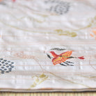 Close-up of a quilt with floral patterns and embroidered designs.