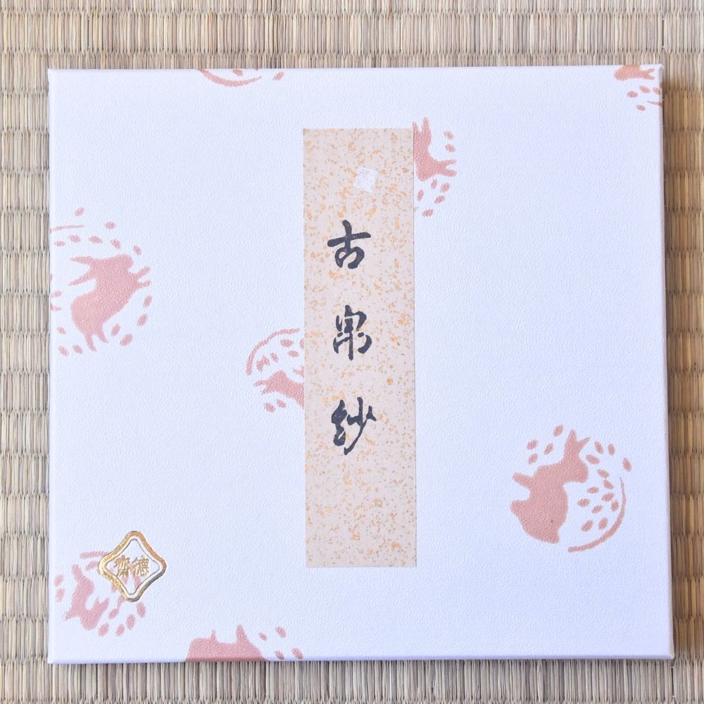 White card with pink bunny designs and text on a woven mat background