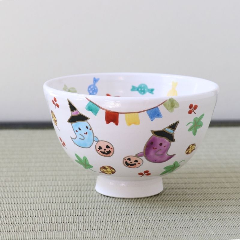 Hand-painted Kyo Ware Halloween matcha bowl featuring colorful ghosts, pumpkins, autumn leaves, and festive decorations on a white chawan