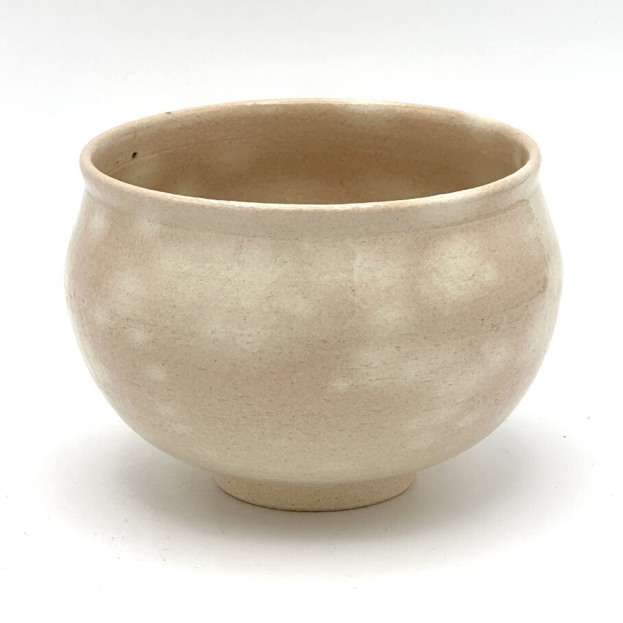 Reverse view of the Kyo-yaki Momiji Ryusui matcha bowl highlighting its rounded form and softly mottled warm beige glazed surface