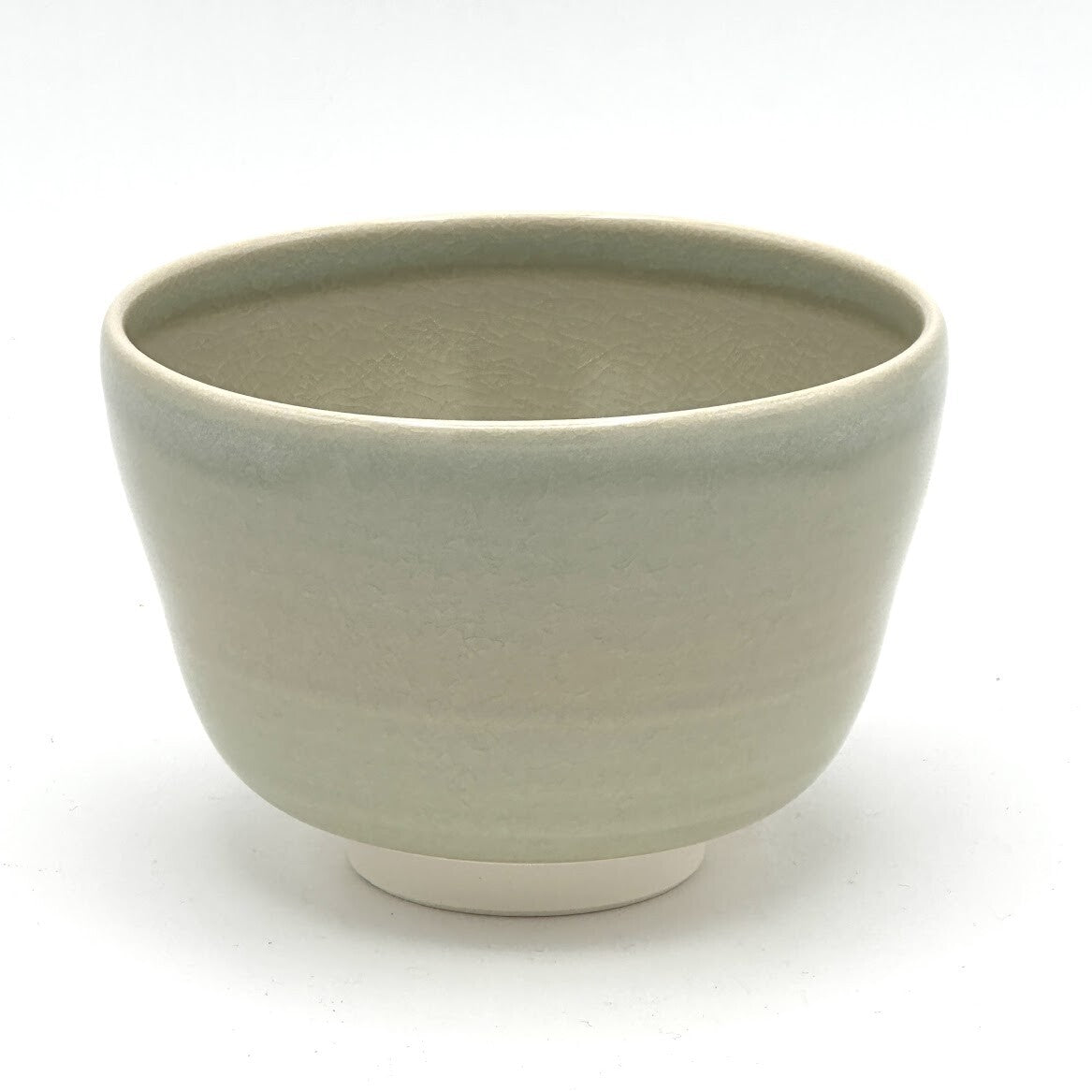 Reverse view of the Kyo-yaki Sakurazume matcha bowl highlighting its rounded form and softly textured beige glazed surface