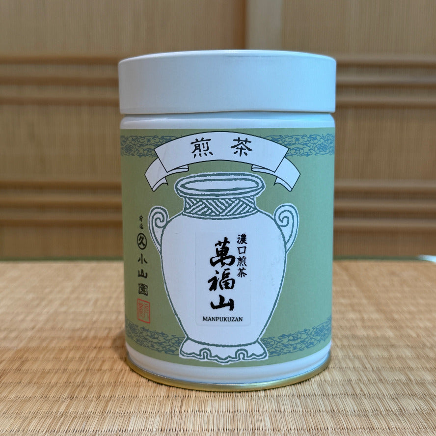 Tea canister with green and white design on a wooden surface