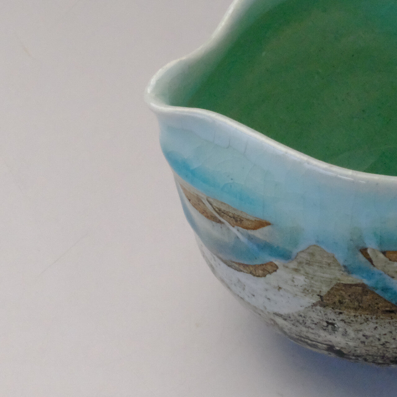 Close-up of the pouring spout and rim of the mint blue Mino Ware katakuchi bowl.