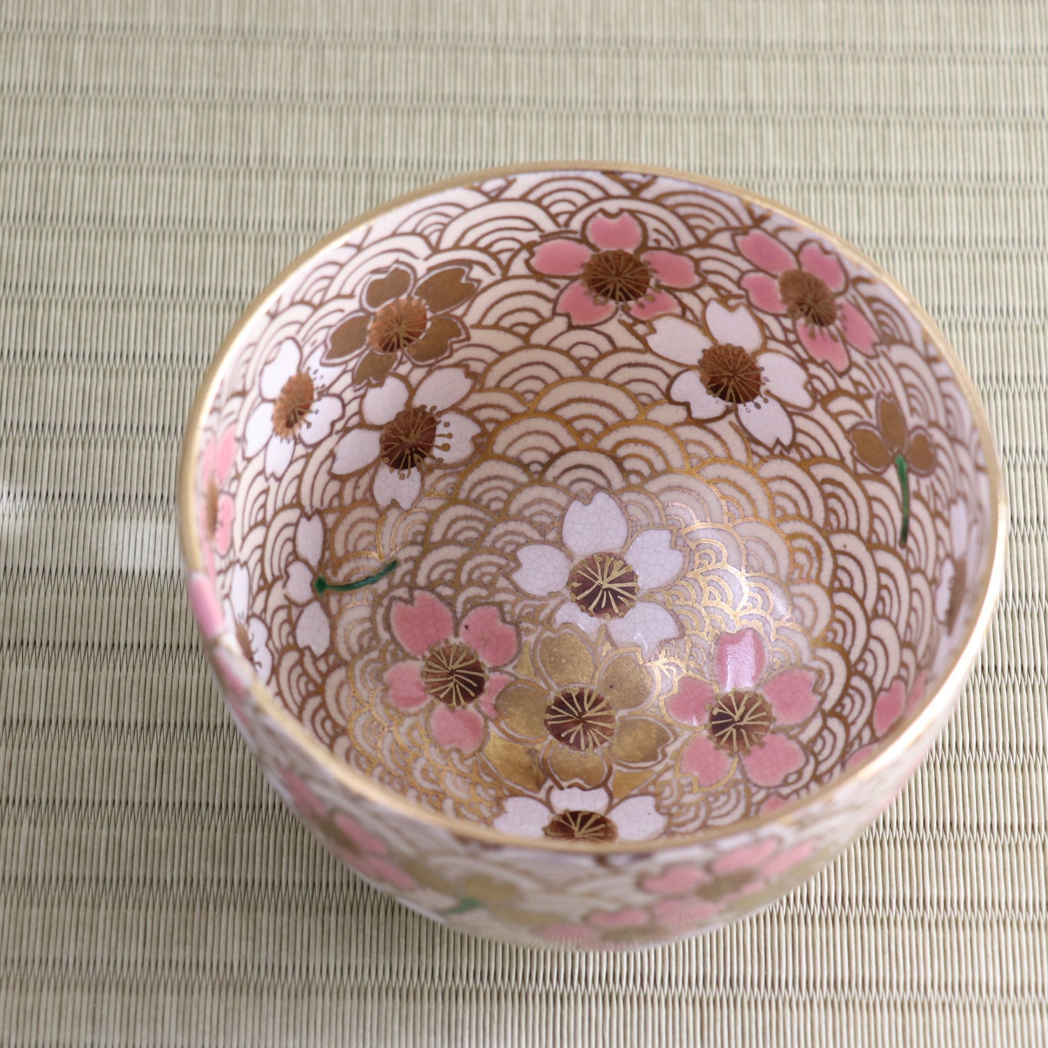 Top view of the peach blossom matcha bowl showing its richly decorated interior with pink blossoms and a detailed repeating background pattern.