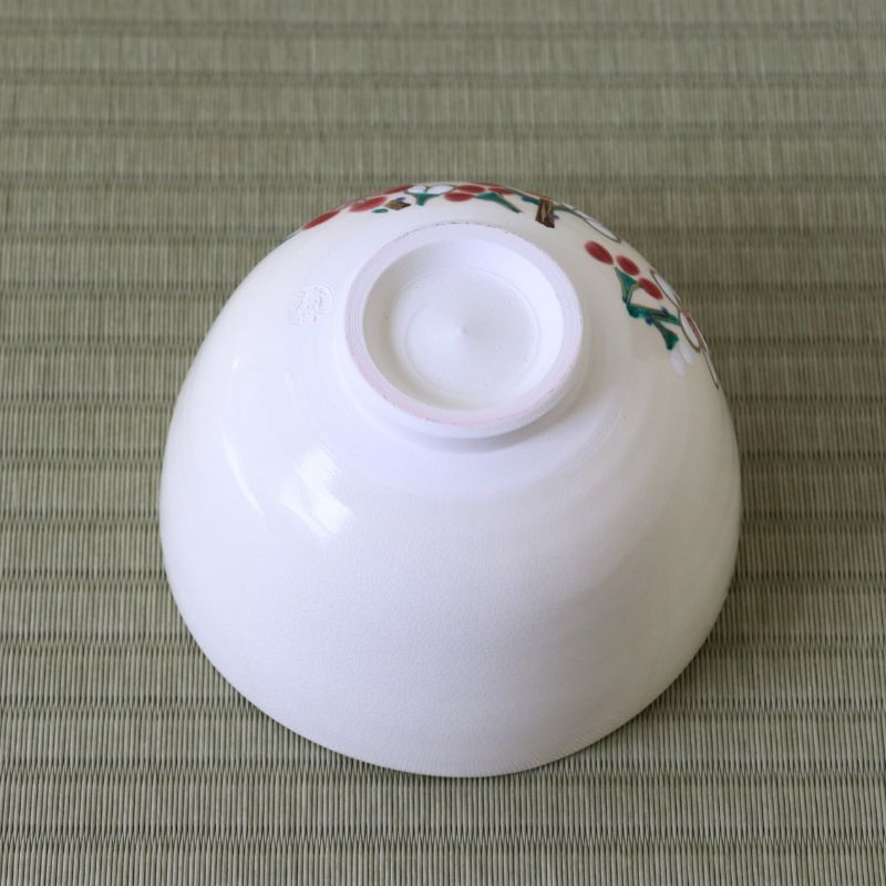 Underside view of the Kyo Ware matcha bowl showing the raised foot ring and red and white plum blossoms along the upper exterior.