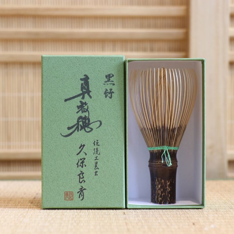 Ryosai Kubo handcrafted Takayama chasen made from Japanese black bamboo with Yellow Green #24 thread, displayed beside its presentation box