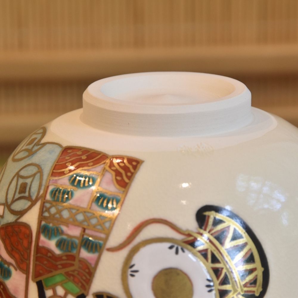 Close-up of the underside and raised foot of the Sayaka Isaka matcha bowl with surrounding imperial doll and drum motifs.