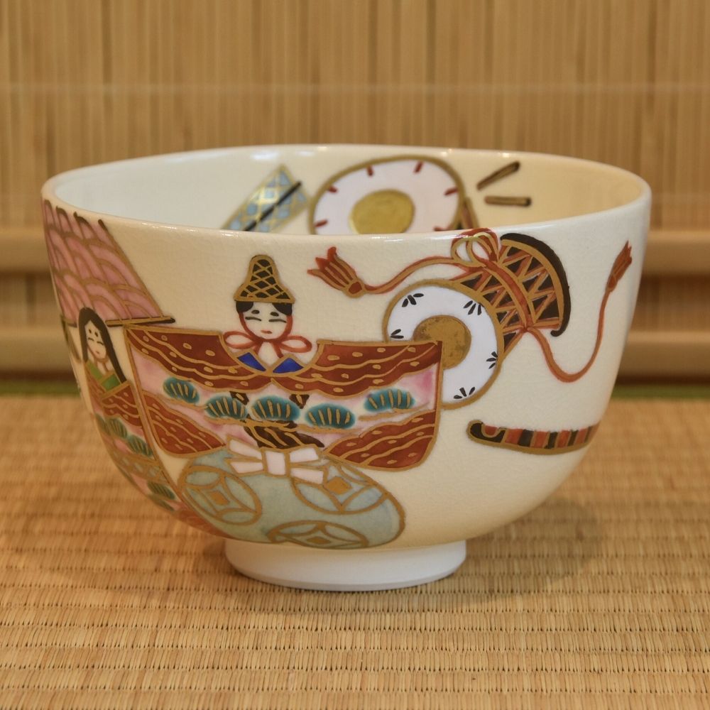 Right-side view of the Sayaka Isaka matcha bowl showing the imperial couple, fans, textiles, and ceremonial accessories.