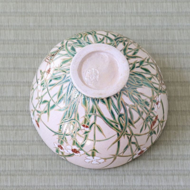 Bottom view of the Shisen Asano Nadeshiko matcha bowl showing its circular foot and floral decoration continuing across the pale pink exterior
