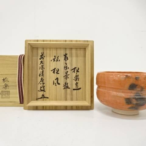 Pre-owned Shoraku Sasaki Red Raku matcha bowl titled Matsukaze displayed beside its open inscribed wooden storage box.