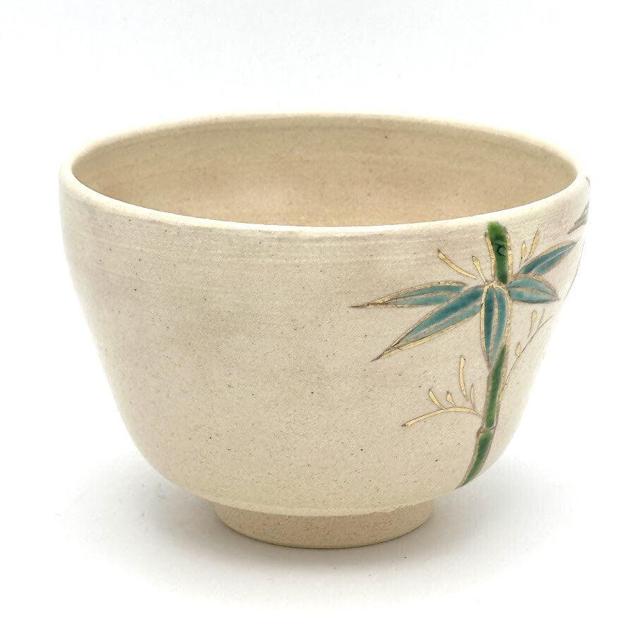 Side view of the Kyo Ware matcha bowl highlighting hand-painted bamboo in green and blue on the warm beige glaze