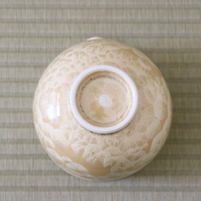 Underside view of the Tōan Hana-Kesshō golden flower katakuchi bowl showing its circular ceramic foot and crystalline glaze across the base
