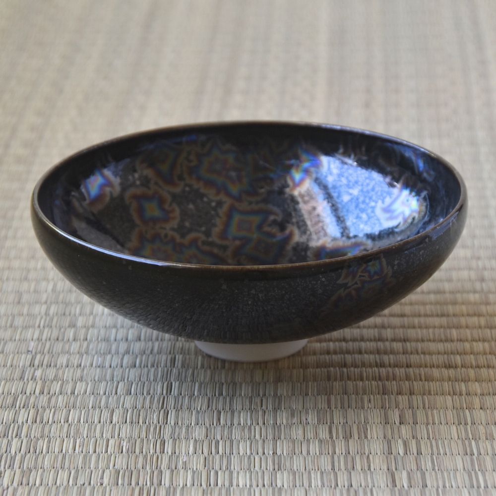 Touan flat matcha bowl featuring a black Hoshi-Kessho Star Crystal glaze with intricate iridescent star-like crystalline patterns