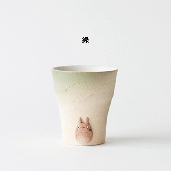 Gradient ceramic cup with a character design on a white background