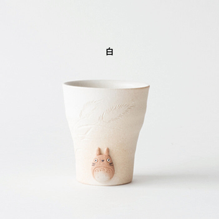 White ceramic cup with a small character on a white background