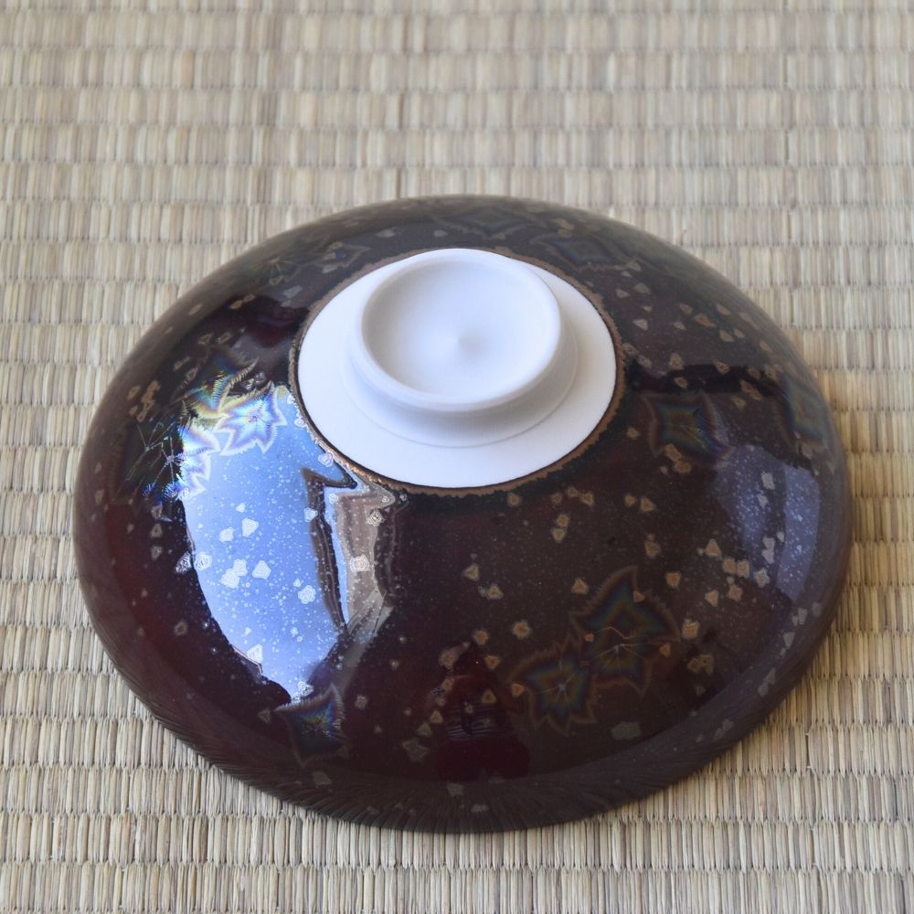 Bottom view of the Touan Hoshi-Kessho wine red matcha bowl showing its circular white ceramic foot surrounded by dark crystalline glaze