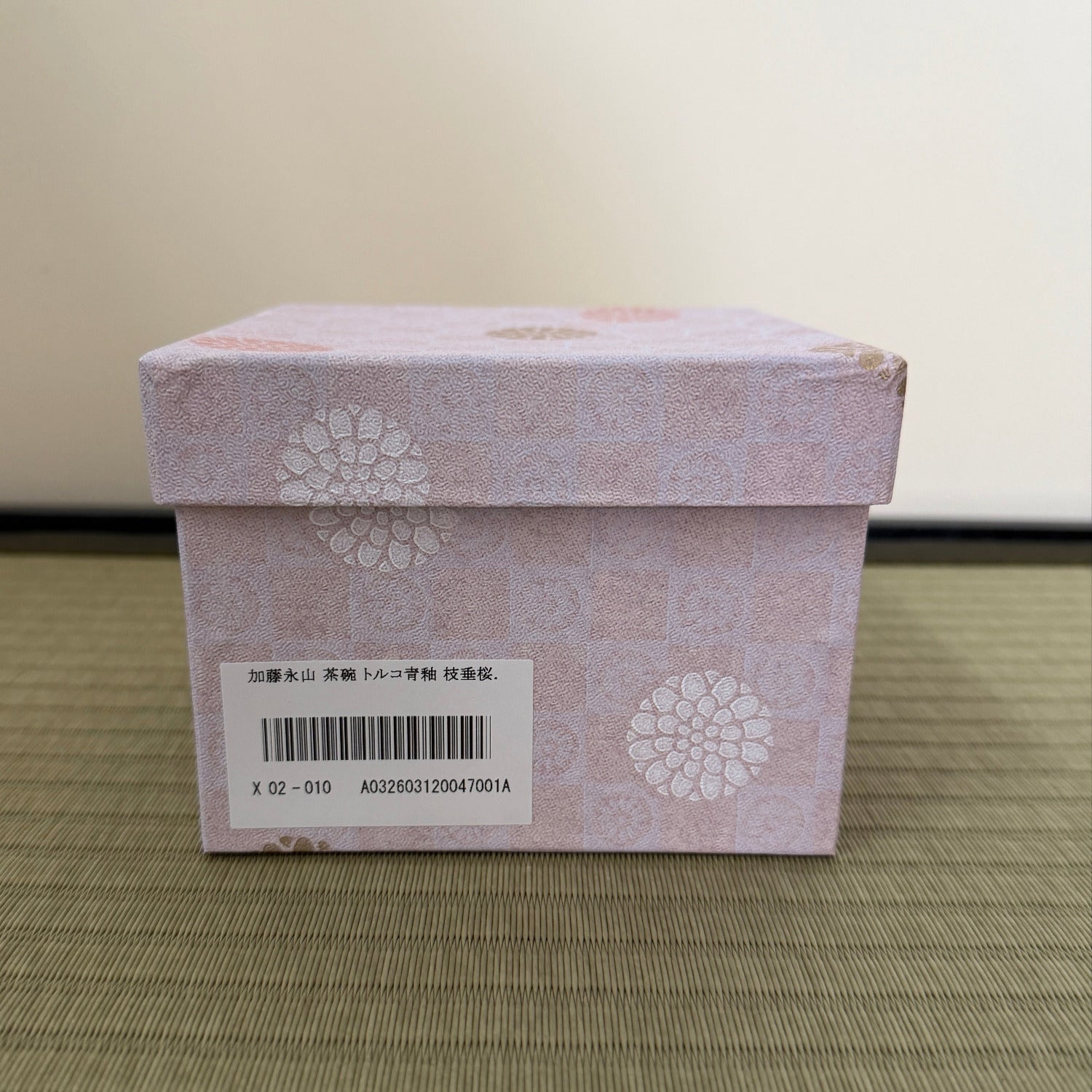 Pink patterned presentation box with product label for the turquoise weeping cherry blossom Kyo Ware matcha bowl.