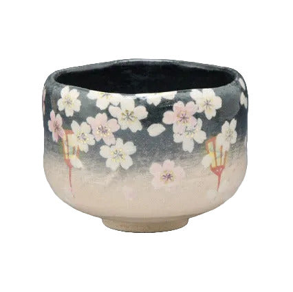 Yoizakura Raku-style Kyo Ware matcha bowl with pale pink and white evening cherry blossoms against a dark glaze